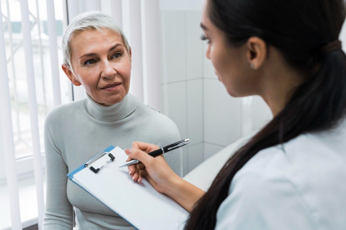 Dentist consulting with older woman in clinic